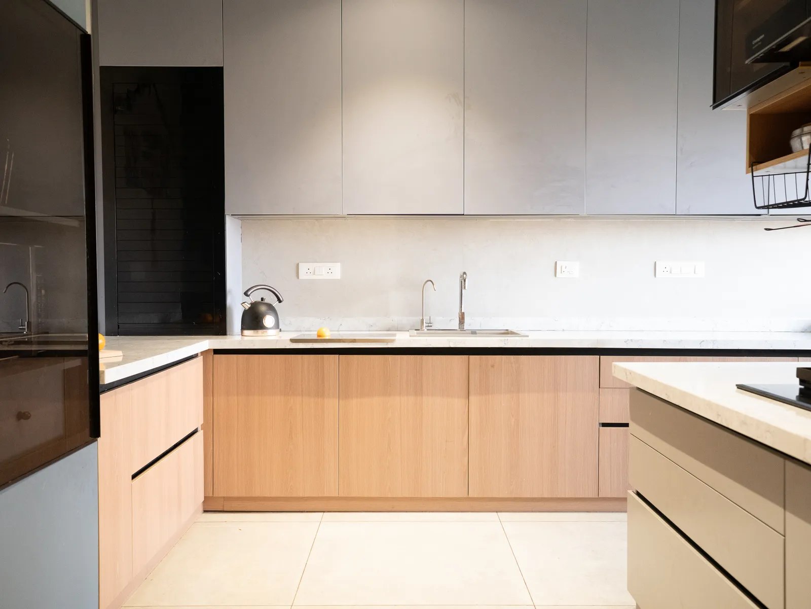 Kitchen with oak-finish cabinets and grey wall units — Amlan's Residence